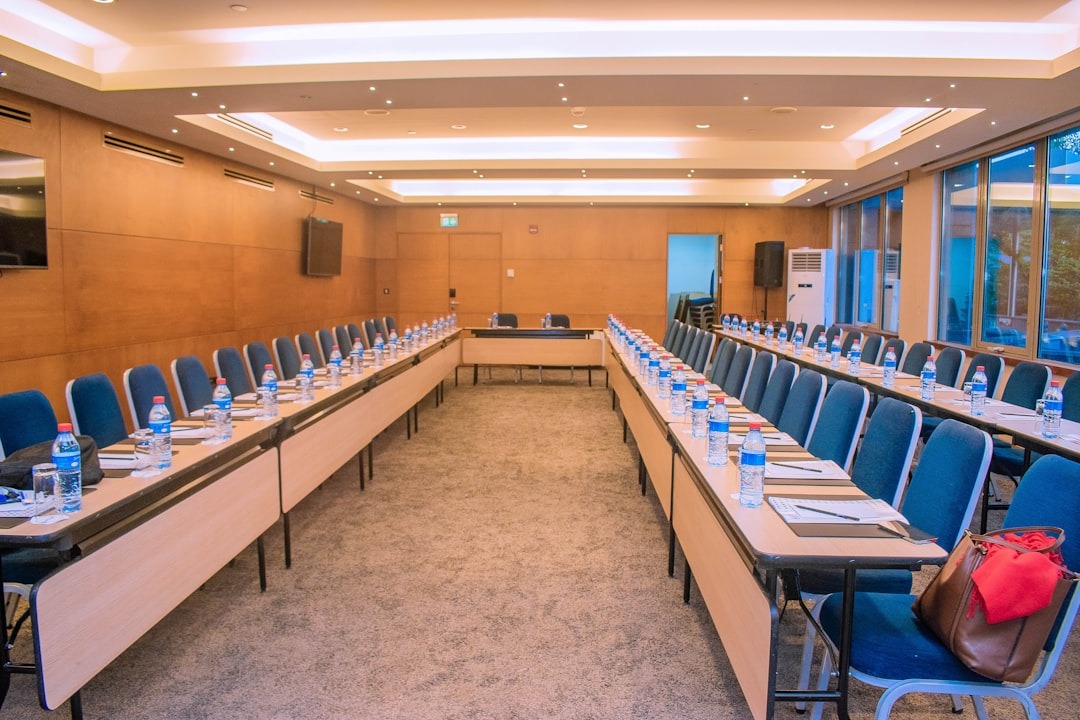 Modern conference room with wooden tables arranged for a meeting.